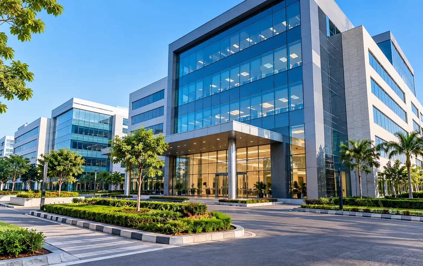 A modern glass-fronted corporate campus with landscaped grounds